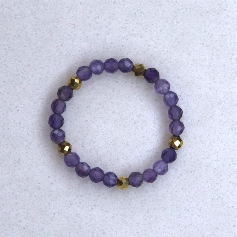 Gemstone amethyst ring on spotted white marble background