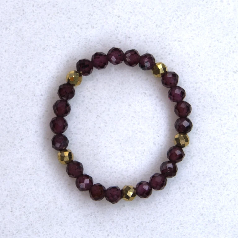 Gemstone garnet ring on spotted white marble background