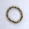 Gemstone gold hematite ring on spotted white marble background