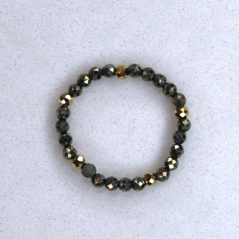 Gemstone pyrite ring on spotted white marble background