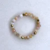 Gemstone rhodochrosite ring on spotted white marble background