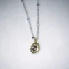 close up view sterling silver hope necklace with a gold vermeil polki diamond pendant on a white speckled background