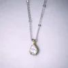 close up view sterling silver hope necklace with a gold vermeil polki diamond pendant on a white speckled background