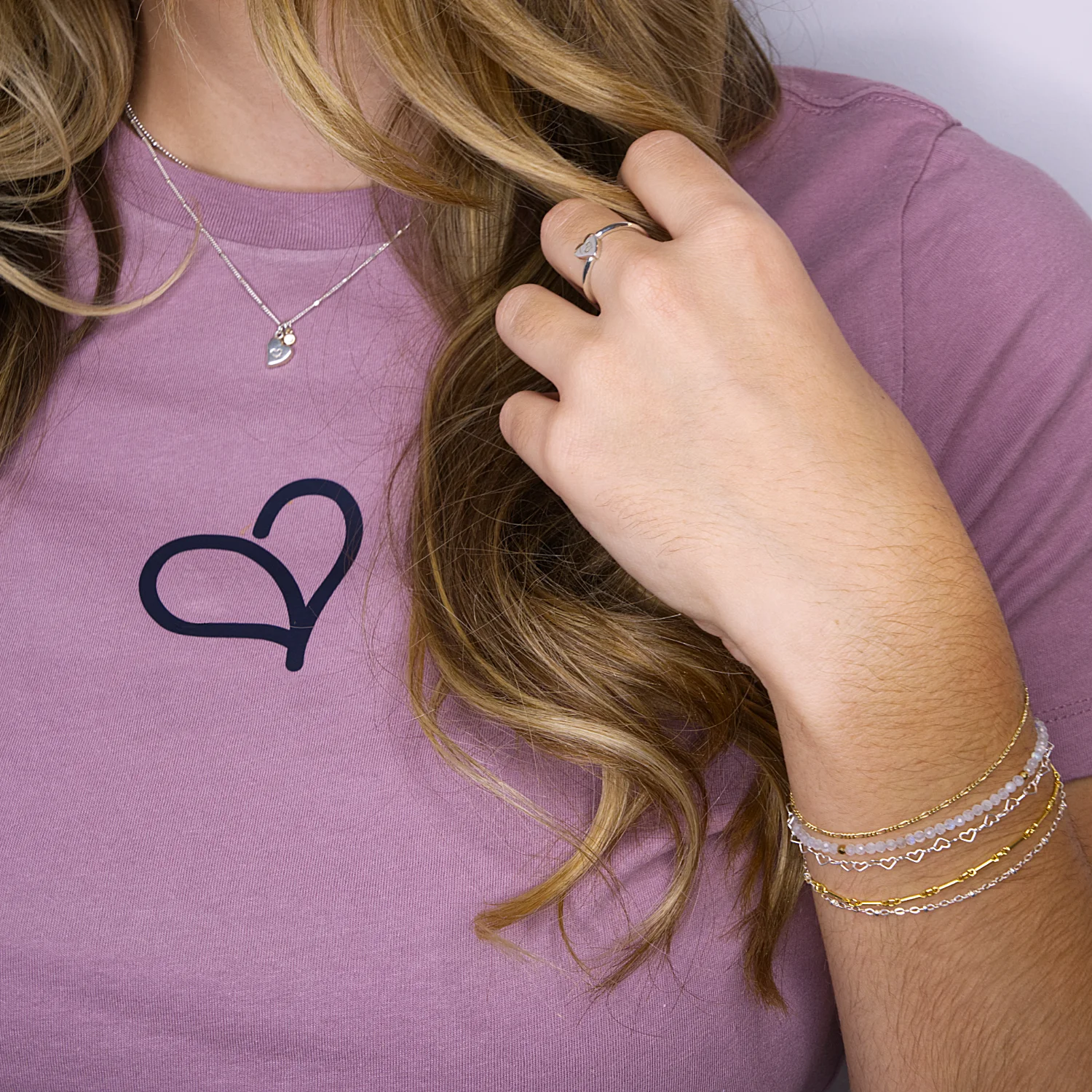 Model wearing an I love Myself Fealing Authentic logo t-shirt and wearing gold and silver gemstone bracelets