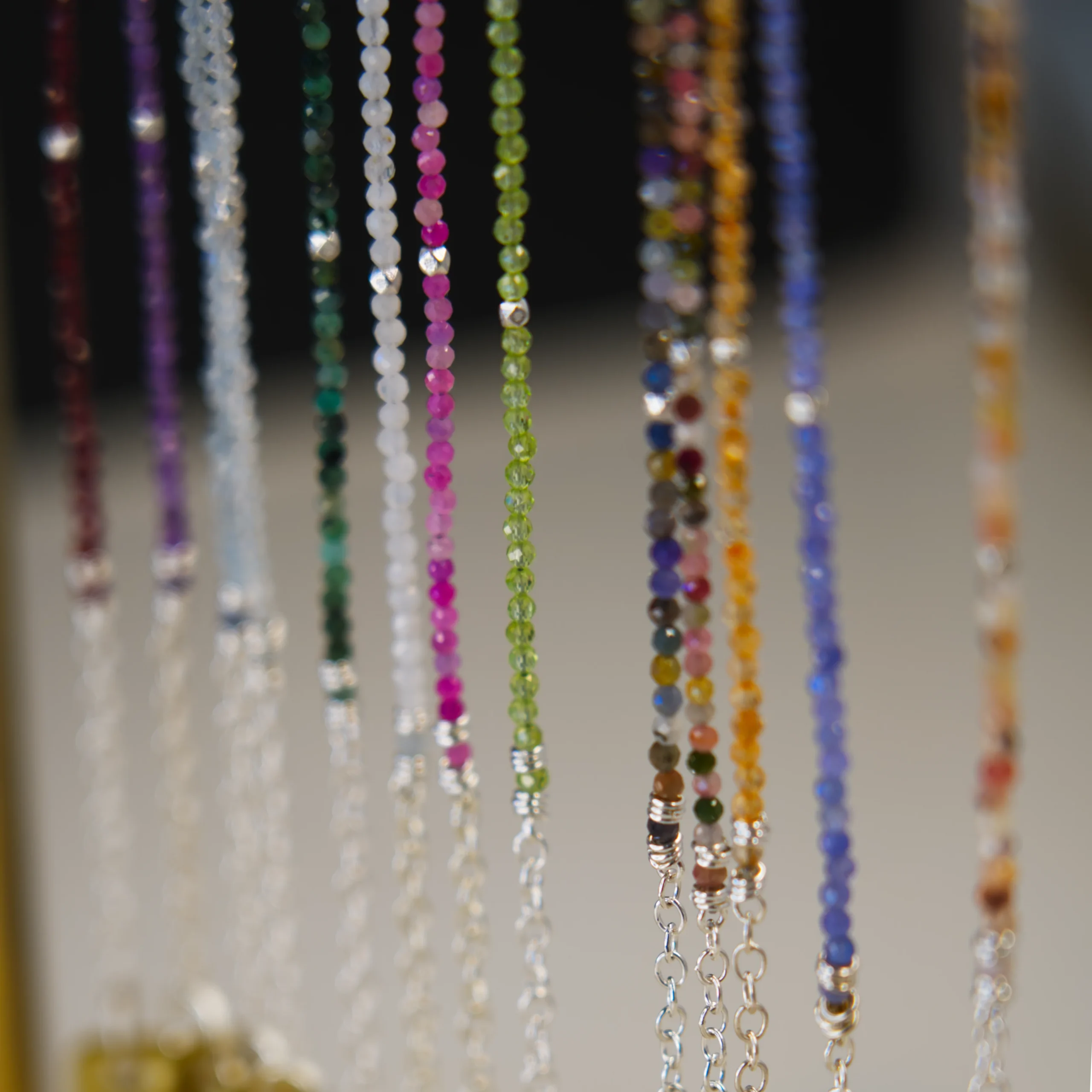 close up hanging assortment of gemstone bracelets